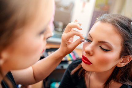 Make-up artist applying the false eyelashes to model. Close-up. Grainne McCoy